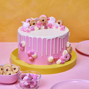 Pretty In Pink Cake with white chocolate drip, pink meringues, Jammy Dodgers, and vanilla buttercream decoration.